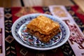 Paklava on a ceramic plate with a napkin in the background. Table setting in a Crimean Tatar restaurant in Odessa, Ukraine Royalty Free Stock Photo