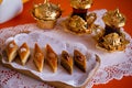 Paklava on a white napkin, on a wooden plate, on a table, against national glasses with tea and sugar bowls.