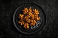 Pakoras On Black Matte Plate. Generative AI