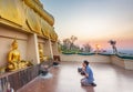 Lao family worship at the feet of the giant Golden Buddha of Wat Phousalou