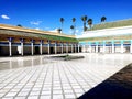 Morocco. Palace El Bahia Marakesh. Interior courtyard with white floor and row of columns on a background of palm trees and blue s Royalty Free Stock Photo