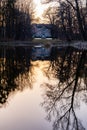 Palace in Pawlowice park at sunset reflected in small lake