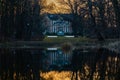 Palace in Pawlowice park at sunset reflected in small lake