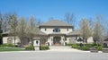 Palatial Luxury Home in Gray Stucco with Flowering Pear Trees