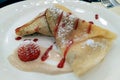 Palatschinken, thin pancakes garnished with cream, syrup and strawberry, on a white plate, Prague Royalty Free Stock Photo