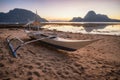 Palawan, Philippines. El Nido shore beach with local banca boat with picturesque sunset golden light scenery and island Royalty Free Stock Photo