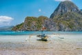 Palawan, Philippines. Traditional filippino banca boat in shallow blue tropical lagoon in El Nido bay. Limestone