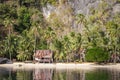 Tropical hut on seacoast. Bamboo cabin on sand beach under palm trees. Ecotourism concept.