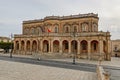 The Palazzo Ducezio in Noto, Sicily, Italy with a rounded staircase in front of the entrance and no people