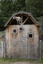 Pale adult goat seen perilously perched in an open gable