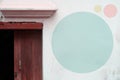 pale blue circle on white concreate wall and wood door