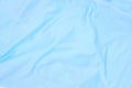 Pale blue fabric top view. Colored textile photo texture. Folded fabric with wrinkles for pattern mockup. Blank textile surface.