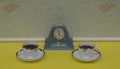 Pale blue Wedgwood watch, Jasperware, with applied relief plate of white clay, next to english teacups and saucers Royalty Free Stock Photo