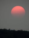 Pale orange sun with smoke layered clouds over FingerLakes sky