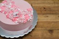 Pale pink cake decorated with meringue flowers and edible paper butterfly Royalty Free Stock Photo