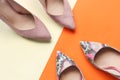 Pale pink and snake print female shoes.Woman high heel shoes on orange and pink background.Trendy fashion shoes. Fashion blog look