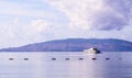 Pale purple sea, boat and mountains at sunrise. Coastal nature background