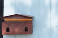 A pale -red mail box hanging on blue wodden background Royalty Free Stock Photo