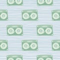 Pale stylized seamless cassette pattern. Light green music disco ornament on blue soft stripped background Royalty Free Stock Photo