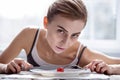 Pale underweight woman cutting a tomato