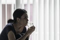 Pale woman drinking a glass of water