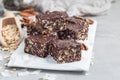 Paleo chocolate energy bars with rolled oats, pecan nuts, dates, chia seeds and coconut flakes, copy space