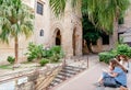 Female tourists reading books and chilling under walls of historical San Cataldo church in old city