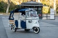 Ape Calessino taxi vehicle parked in front of the palace providing public transportation services for tourists