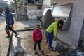 Palestinian children fetch water in jerrycans from a public fountain