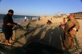 Palestinian fishermen gather their nets at the beach