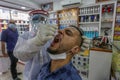 Palestinian medical workers take a random swab samples to check the Coronavirus Covid-19, from a shop owners