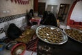 Palestinian women prepare traditional cakes to celebrate the advent of the blessed Eid al-Fitr