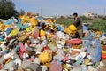 Palestinian youths collect plastic and metal from garbage piles in the town of Khan Yunis, in the southern Gaza Strip