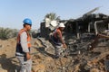 Palestinians gather around the remains of a house destroyed in an Israeli air strike