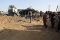 Palestinians gather around the remains of a house destroyed in an Israeli air strike