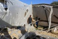 Palestinians inspect the damage at the site of an Israeli air strike