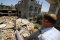 Palestinians inspect their destroyed houses by recent Israeli air strikes in the Gaza Strip