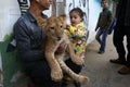 Palestinians plays with a lion cub on the streets of the refugee camp