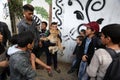 Palestinians plays with a lion cub on the streets of the refugee camp