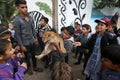 Palestinians plays with a lion cub on the streets of the refugee camp