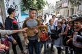 Palestinians plays with a lion cub on the streets of the refugee camp