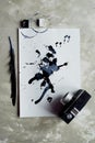 A palette of black and white paint. a sheet of white art paper with black dye ink.Old retro camera