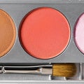 Palette of brown and terracotta eye shadow and makeup brush, top view Royalty Free Stock Photo