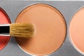 Palette of brown and terracotta eye shadow and makeup brush, top view Royalty Free Stock Photo