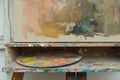 palette on an easel shelf with a halfpainted canvas above Royalty Free Stock Photo