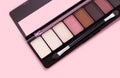 Palette of eyeshadows in brown tones, matte and shimmer eyeshadows on a pink background