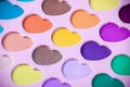 Palette of eyeshadows with multicolor heart-shaped refilles close up. Eyeshadows in macro. Cosmetic brush.