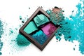 Palette with scattered bright turquoise and purple eyeshadow cosmetic powder