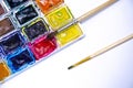 Palette with watercolors and brushes for paints on a white background Royalty Free Stock Photo