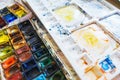 Palette with watercolors in different colors. Various brushes and pencils for drawing prepared by the artist for work. Royalty Free Stock Photo